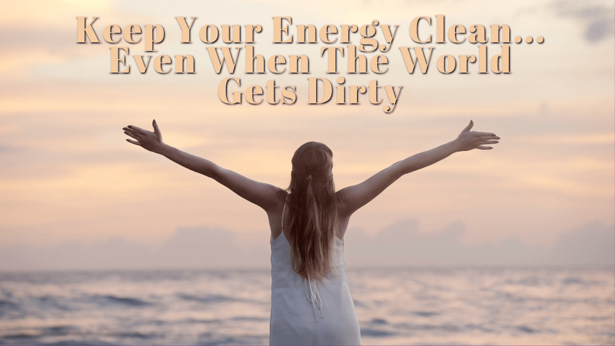 "Keep your energy clean... even when the world gets dirty." Background is a woman facing the ocean with her arms spread wide.